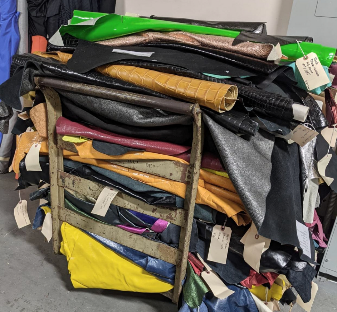 Stack of various colored leather hides with tags ostacked on a cart at fabscrap rescued leather