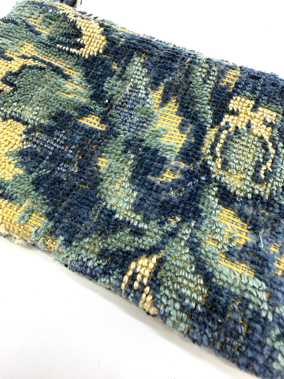 Close-up of a patterned fabric with blue and yellow design on a white background#color_bleu-tapestry