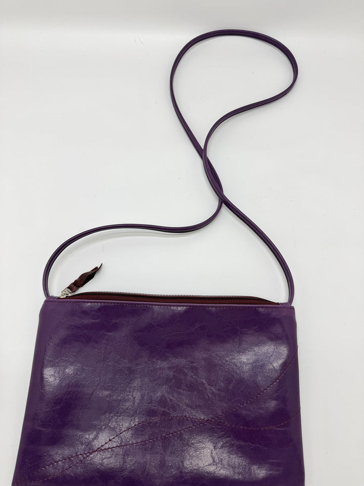 Purple leather crossbody bag with a strap on a white background#color_plum