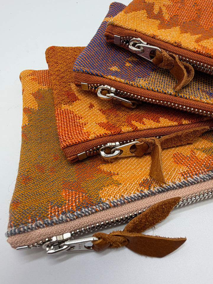 Fabric pouches with zippers in various colors on a white background#color_orange-ferns