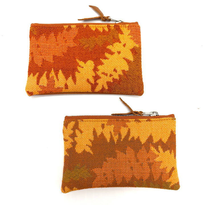 Two woven pouches with a leaf pattern on a white background#color_orange-ferns