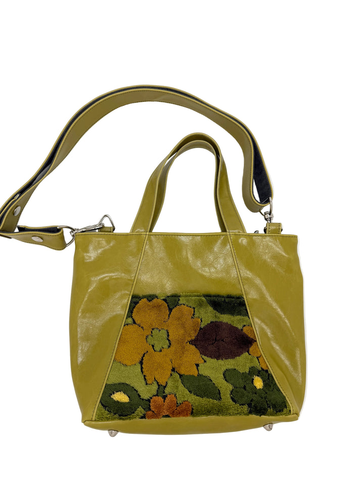 Green handbag with floral design on a white background