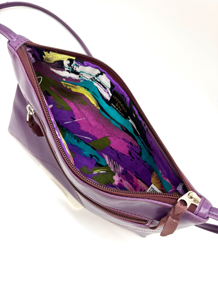 Purple handbag with a colorful interior on a white background#color_plum