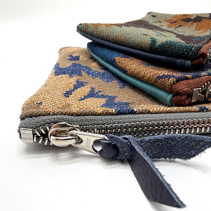 Close-up of a fabric pouch with a zipper, featuring intricate patterns.#color_blue-ferns