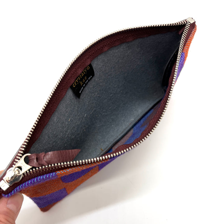 Open zipper pouch with brown and blue pattern on a white background#color_sky-arches-red-purple