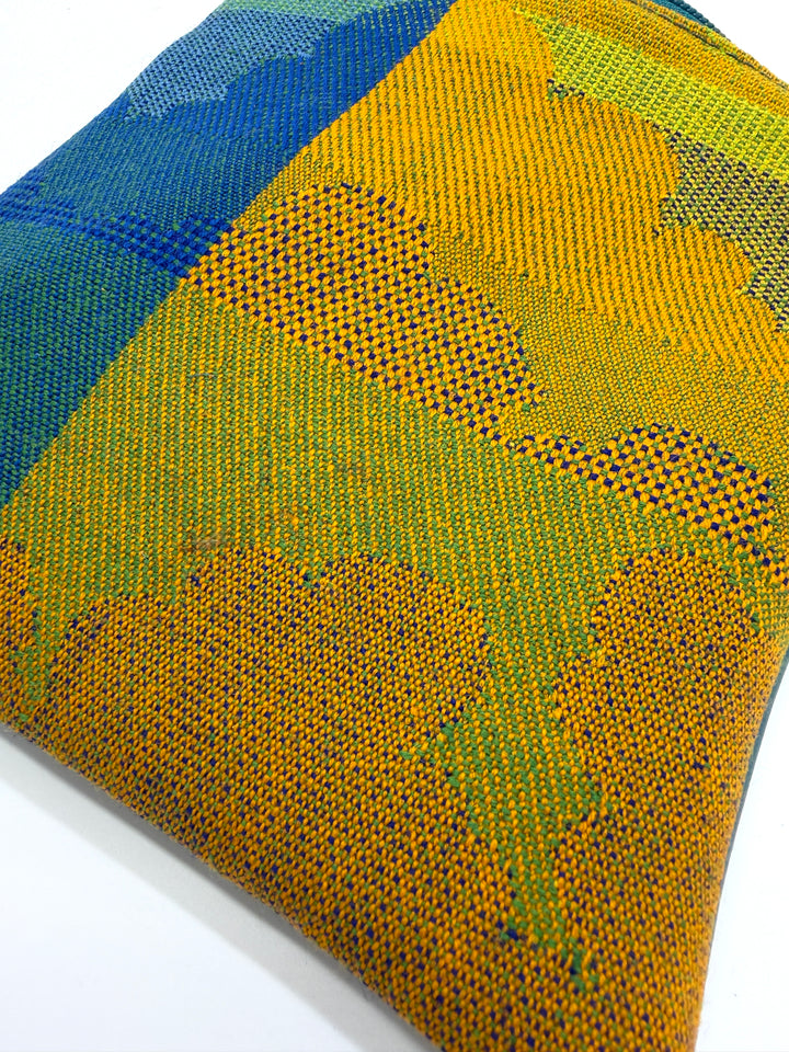 Close-up of a textured fabric with blue and yellow patterns on a white background#color_clouds-warm