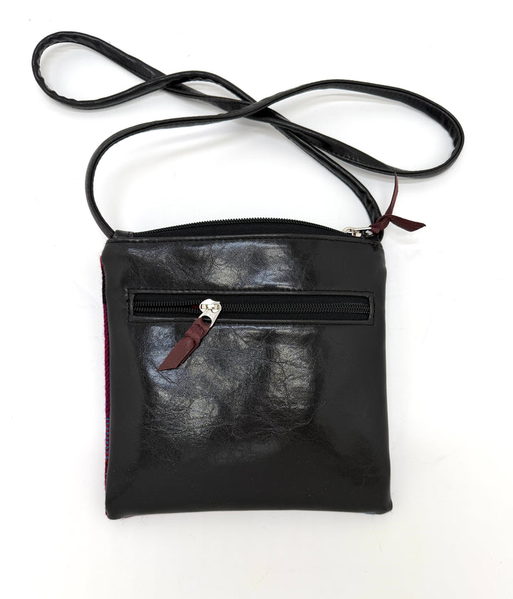 Black leather crossbody bag with a visible zipper on a white background#color_clouds-cool