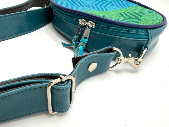 Teal bag with a strap and keychain on a white background#color_navy-teal-hexagon-airplane-fabric