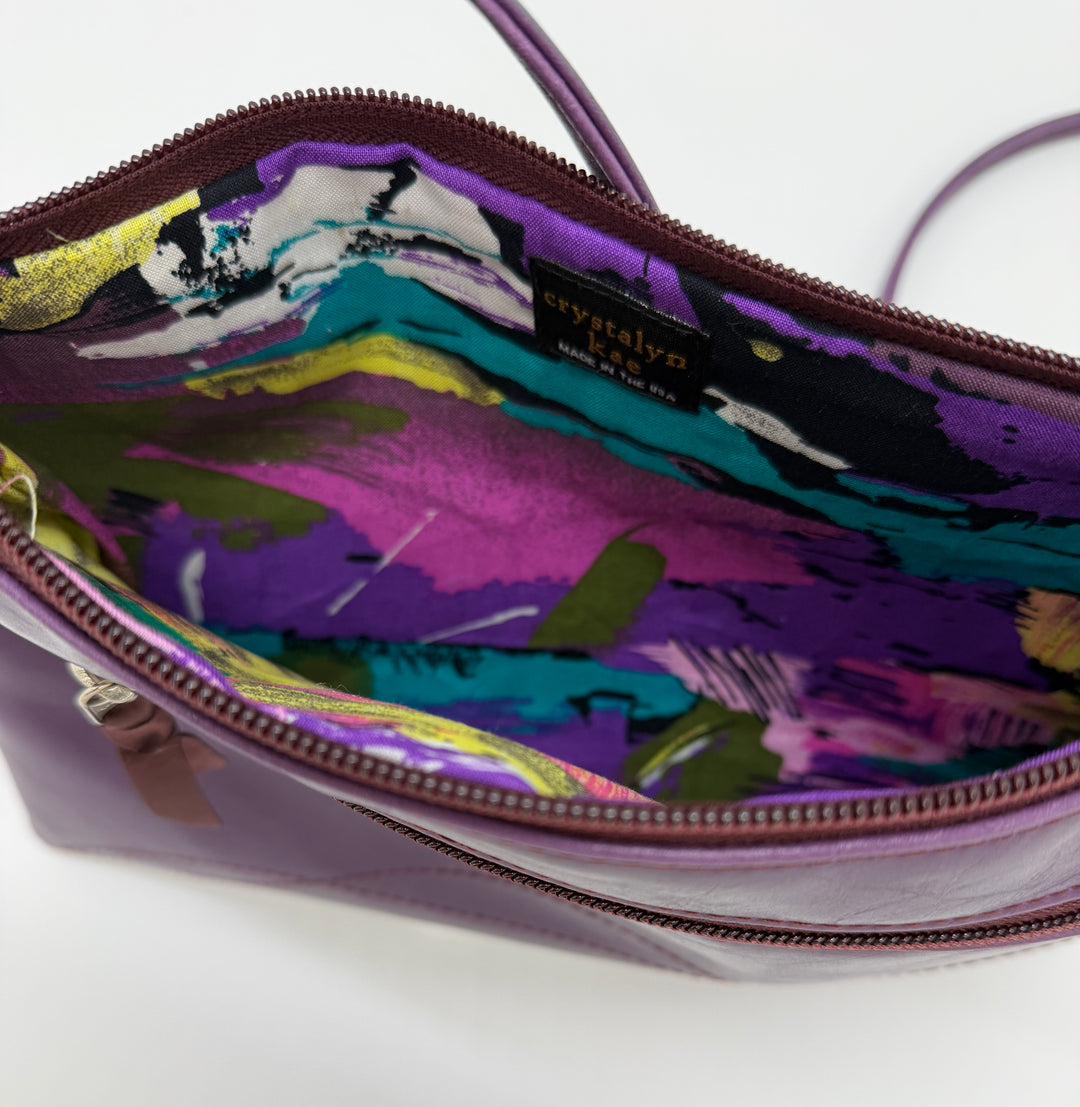 Colorful interior of a handbag with a brand label on a white background#color_plum