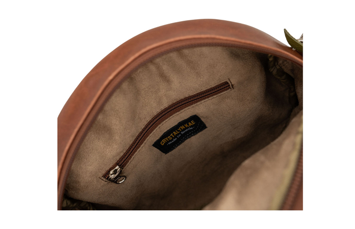 Close-up of a brown leather bag with a visible brand label on a white background#color_aerolinas-argentinas-green