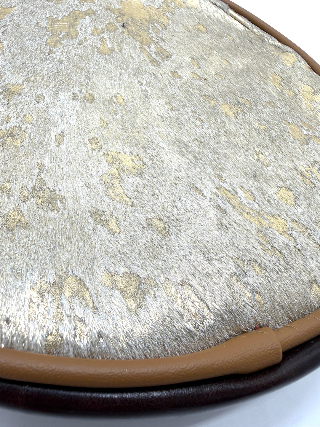 Close-up of a textured surface with a brown border on a white background#color_gold-foil-ponyhair-leather