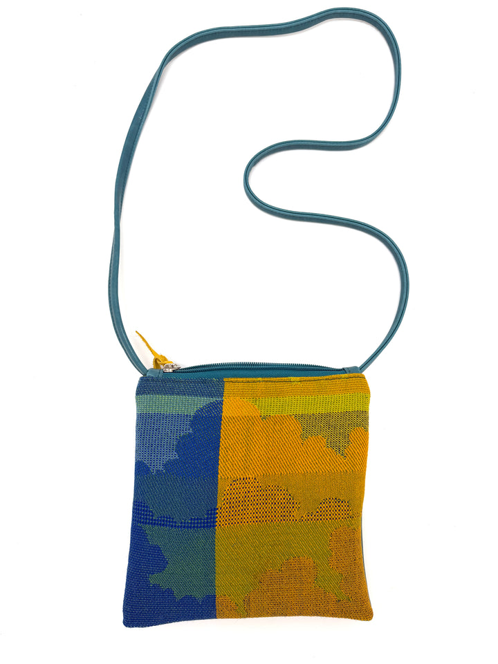 Colorful woven crossbody bag with a blue and yellow pattern on a white background#color_clouds-warm