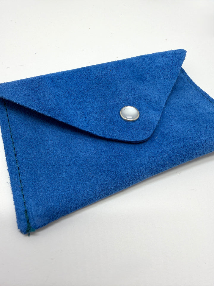 Blue suede clutch with a silver button on a white background #color_blue-suede