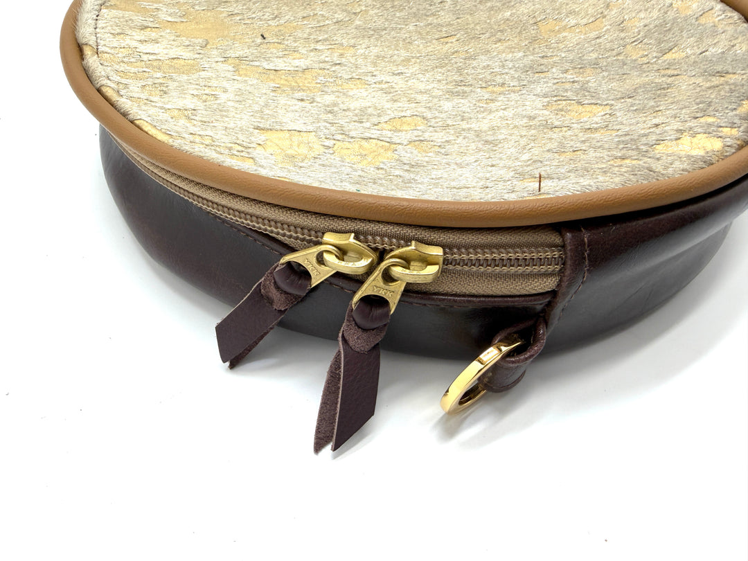 Round pouch with gold zipper and textured beige top on a white background#color_gold-foil-ponyhair-leather