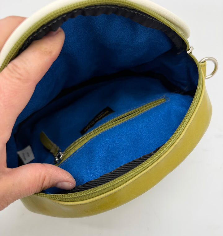 Hand holding a yellow pouch with blue interior on a white background#color_citrine-clouds-airplane-fabric