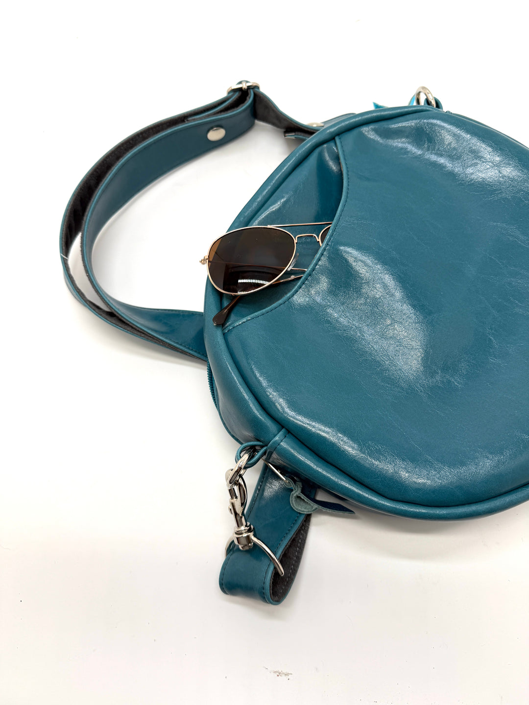 teal blue round bag with sunglasses on a white background#color_navy-teal-hexagon-airplane-fabric