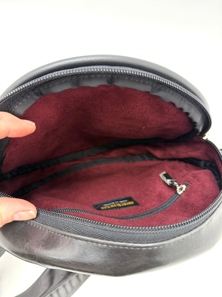 Open black circle purse with maroon interior and visible brand logo on a white background#color_poppy-leopard