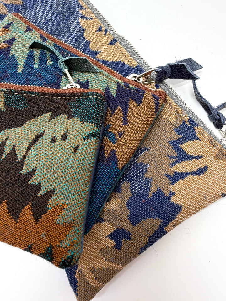 Three patterned pouches with zippers on a white background#color_blue-ferns