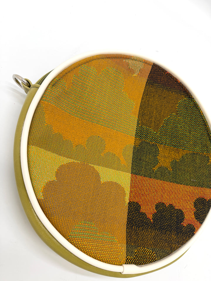Round fabric sample with camouflage pattern in a metal hoop on a white background#color_citrine-clouds-airplane-fabric