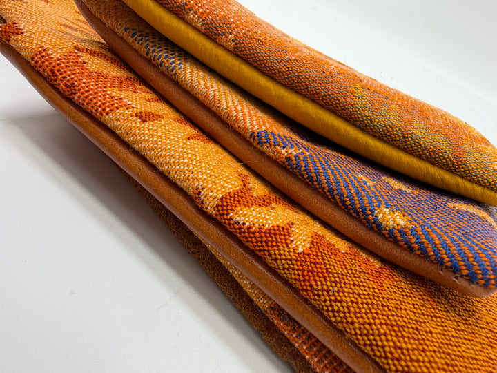 Close-up of textured fabric samples in various colors on a white background#color_orange-ferns