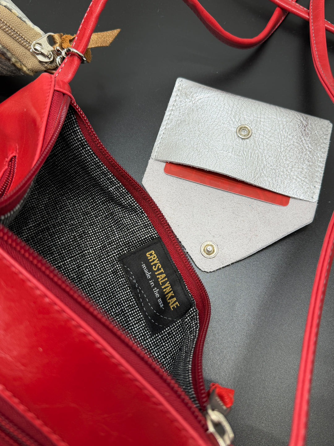 Red handbag with a white cardholder on a black background