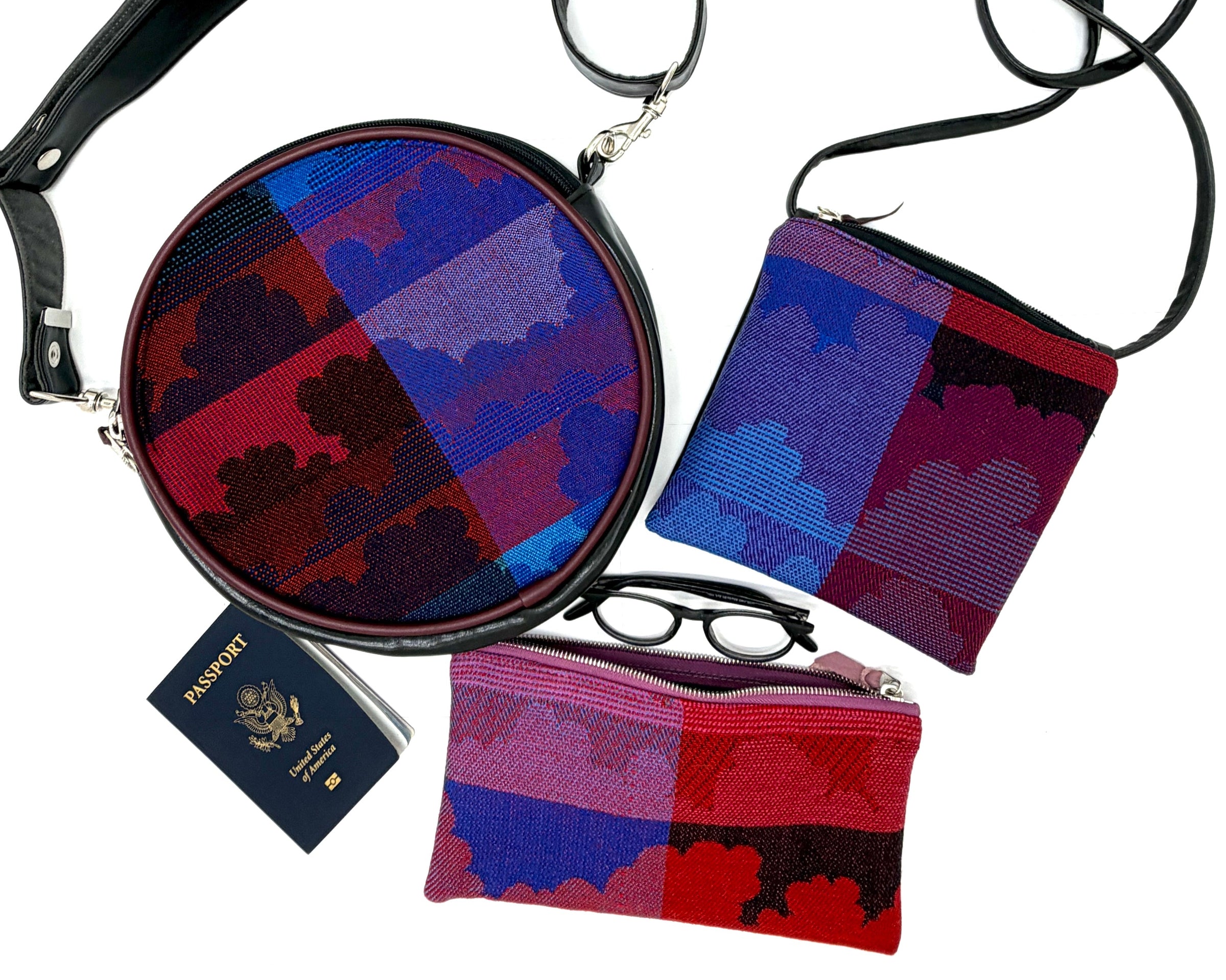 Set of patterned bags and pouches made from vintage airline fabric with motifs of clouds and  a passport on a white background