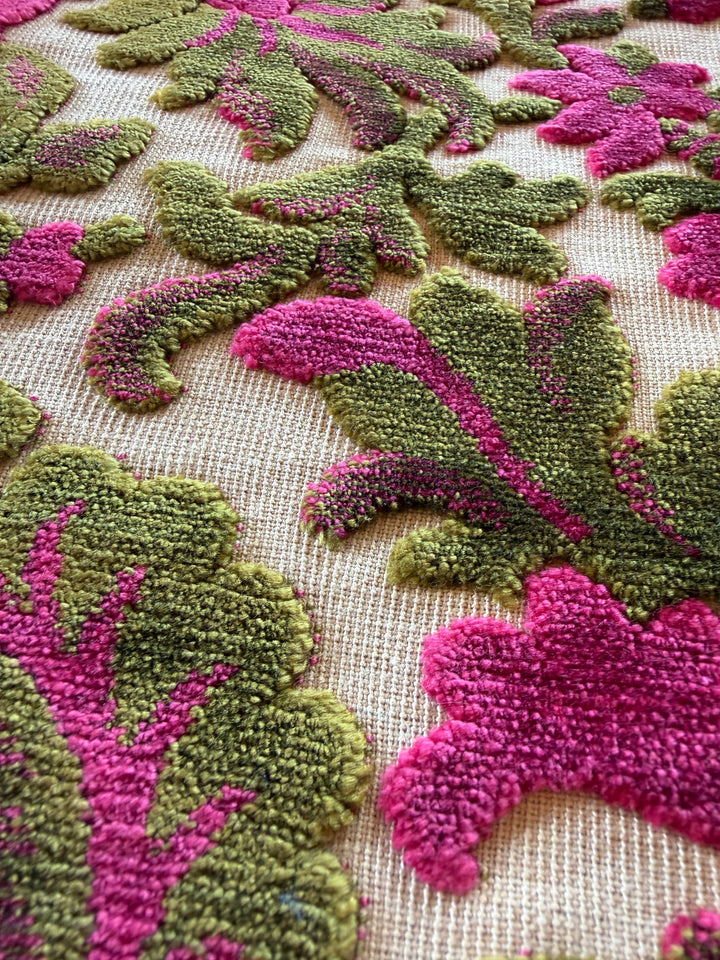 Close-up of a textured fabric with pink and green floral patterns.#color_fuchsia-moss-velvet-floral