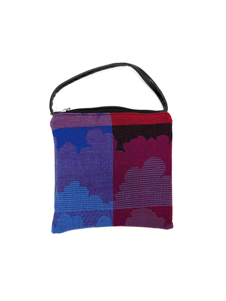 Multicolored woven bag with a black handle on a white background#color_clouds-cool