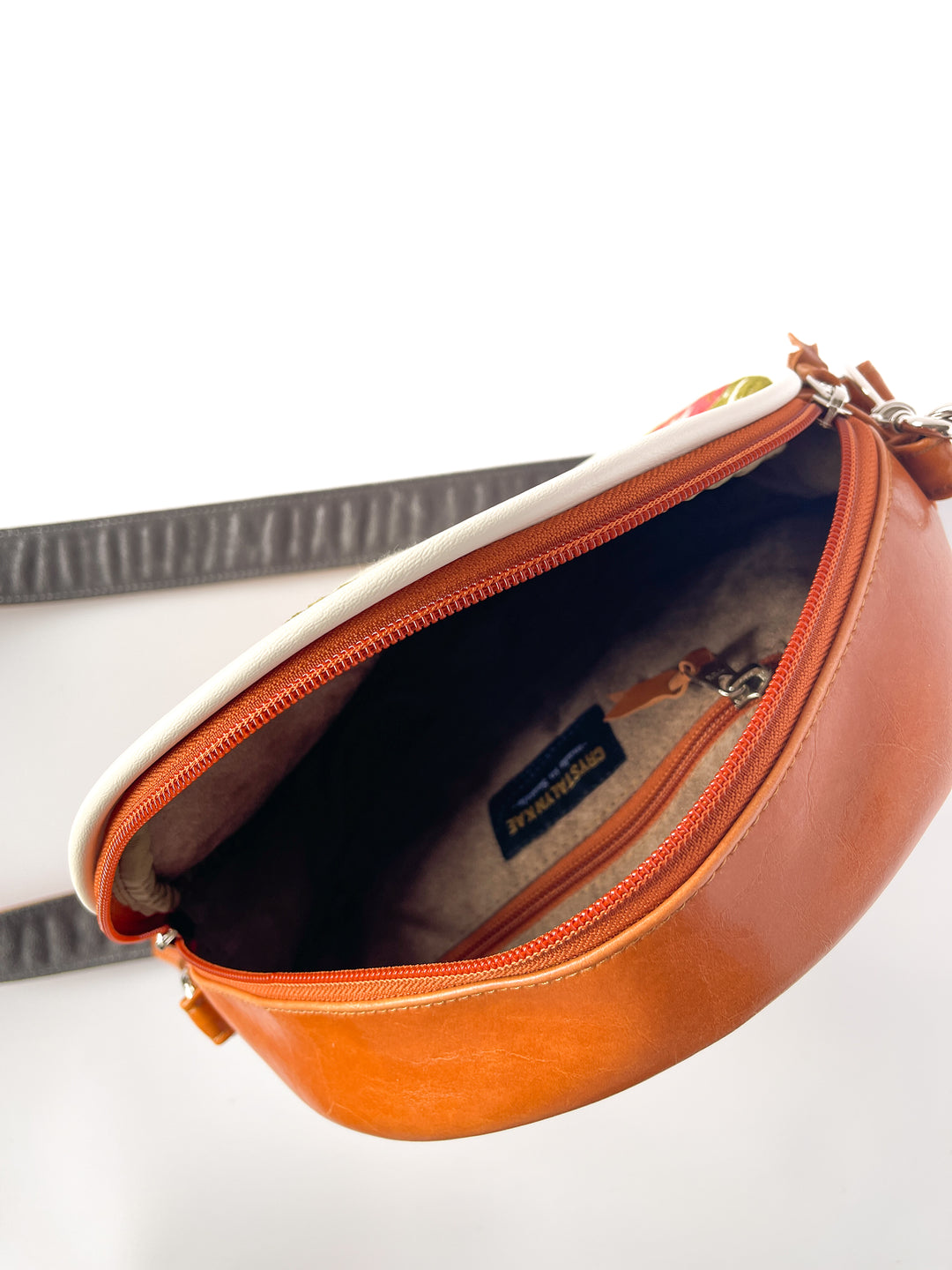 Brown leather bag with a visible brand label on a white background#color_white-french-floral-brocade