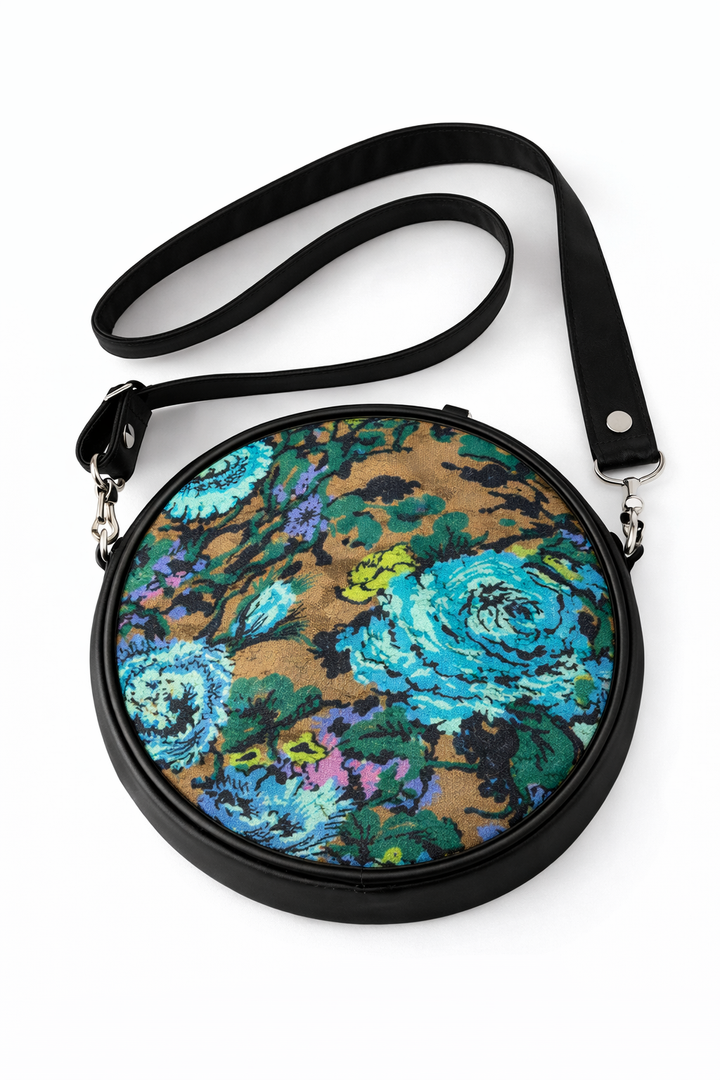 Round floral-patterned handbag with a black strap on a white background#color_midnight-garden