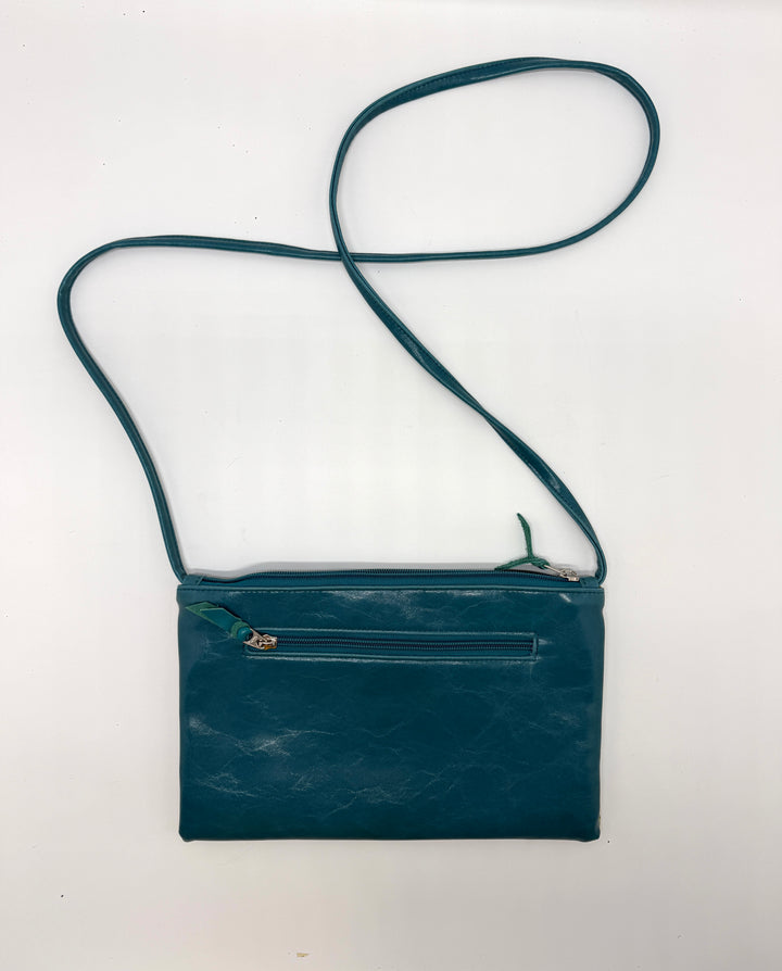 Teal leather crossbody bag with a strap on a white background#color_western-sky-arches-teal-green
