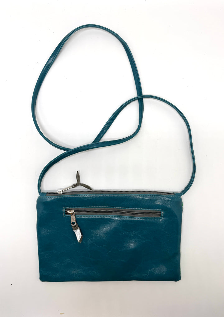 Teal leather crossbody bag on a white background#color_sky-arches-teal-green