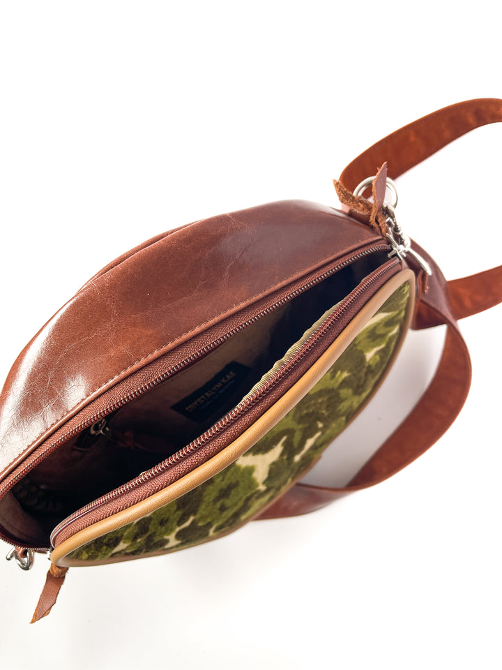 Brown leather bag with camouflage interior on a white background#color_ornate-mossy-green-chenille