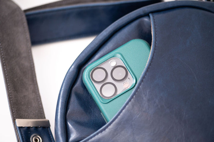 Teal phone case with camera lens design inside a blue leather bag#color_nautical-sailboat-barkcloth