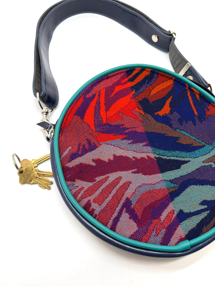 Colorful handbag with a geometric pattern on a white backgroundRound handbag with colorful abstract pattern on a white background#color_palm-fronds-cool