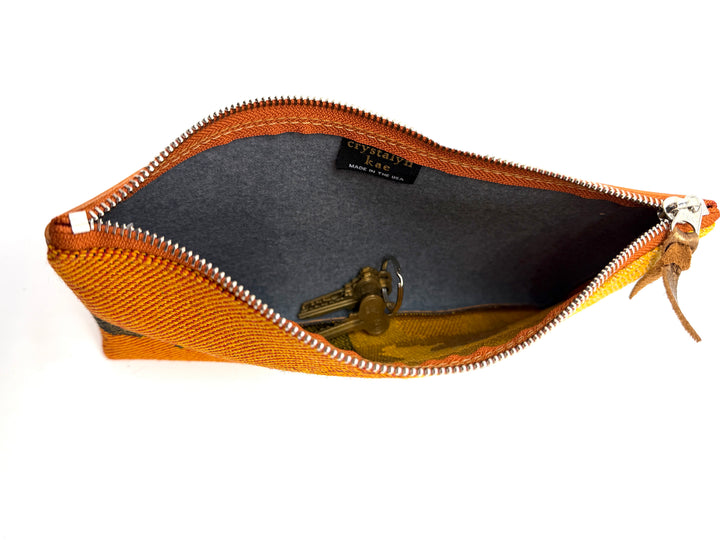 Orange zipper pouch with a gray interior on a white background#color_clouds-warm