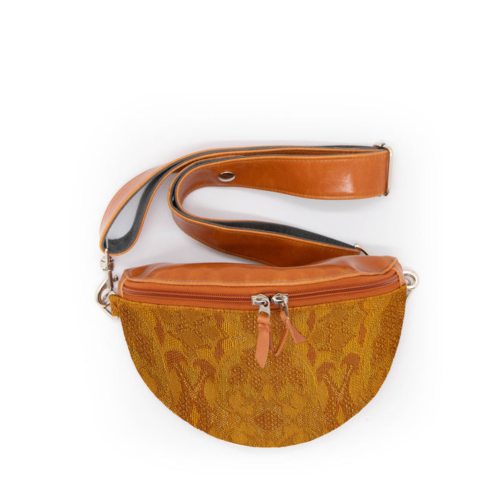 Brown leather waist bag with a patterned design on a white background#color_egyptian-sungold