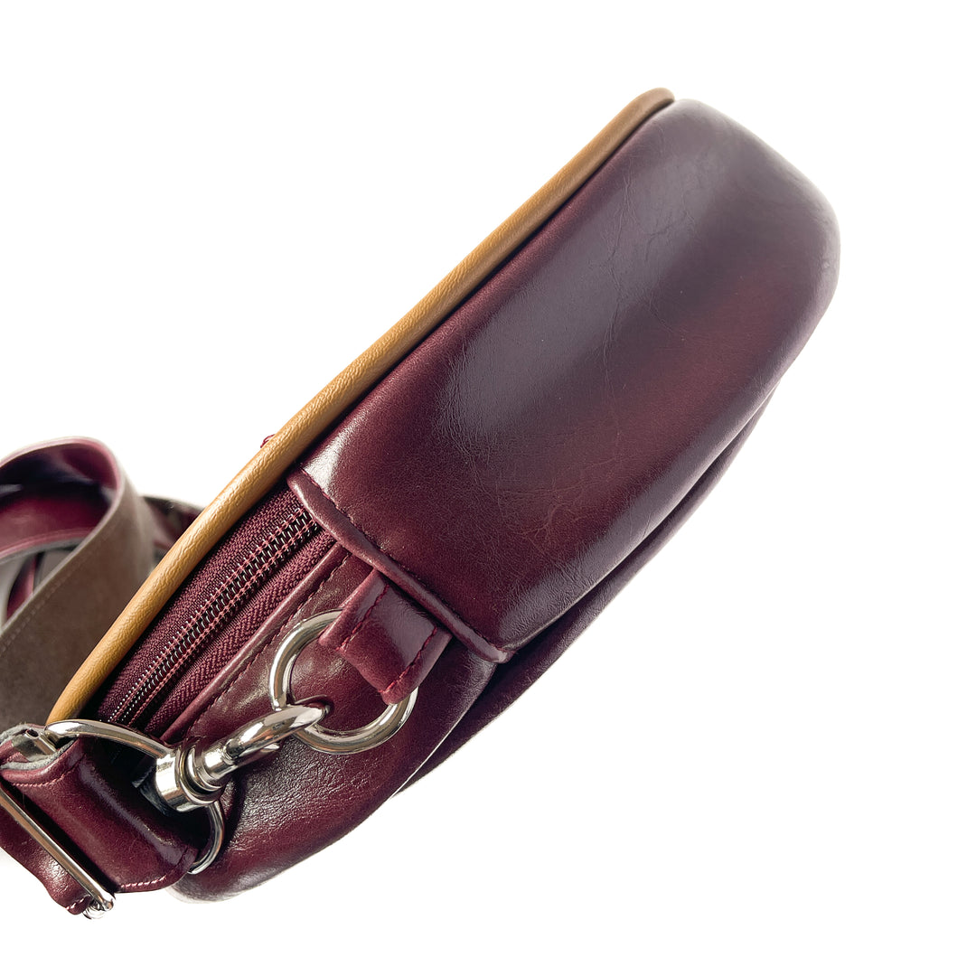 Close-up of a maroon leather handbag with a gold zipper on a white background#color_golden-floral-chenille