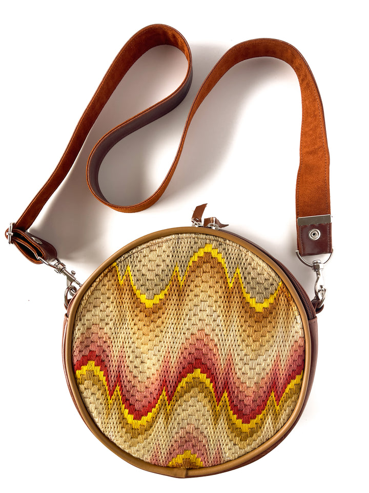 Round woven bag with a brown strap on a white background#color_bargello-needlepoint