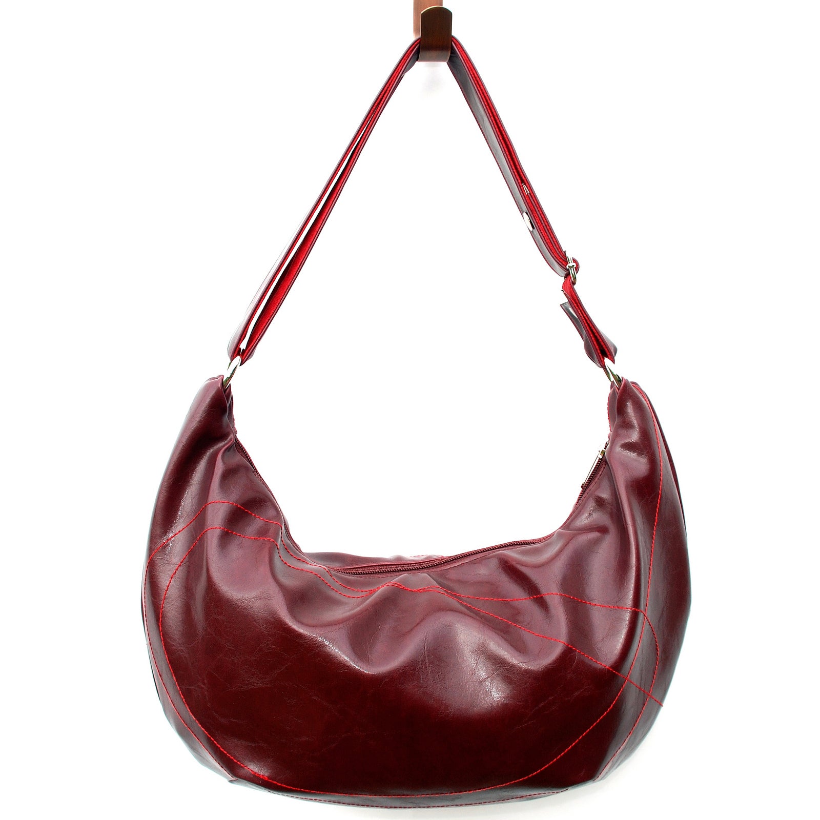 Red leather handbag with a strap on a white background#color_wine