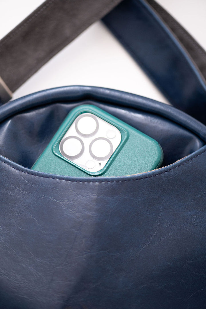 cell phone peeking out of back pocket of navy circle bag#color_nautical-sailboat-barkcloth