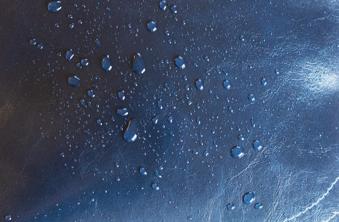 Water droplets on a textured blue coated canvas surface