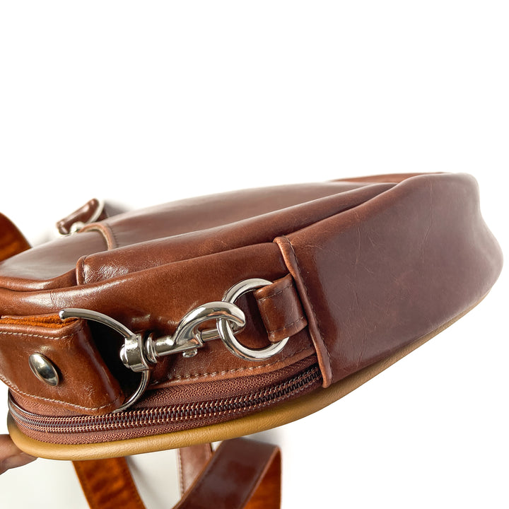 Close-up of a brown leather bag with metal hardware on a white #color_ornate-mossy-green-chenillebackground