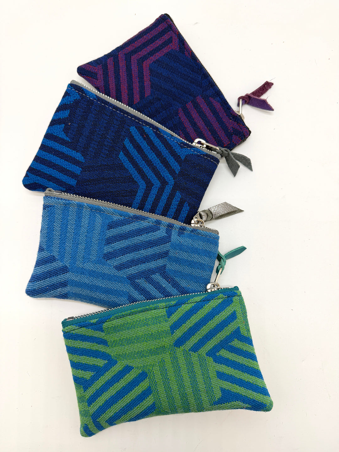 Three patterned zipper pouches in blue, green, and purple on a white background#color_hexagon-cool