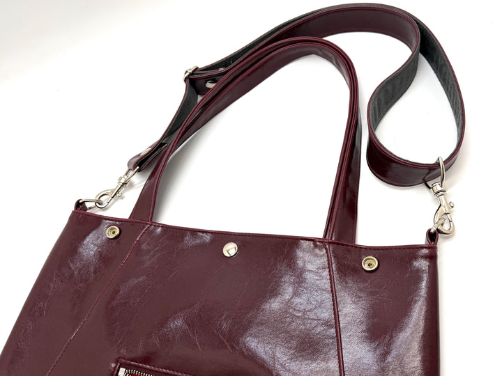 wine leather handbag with a strap on a white background#color_wine